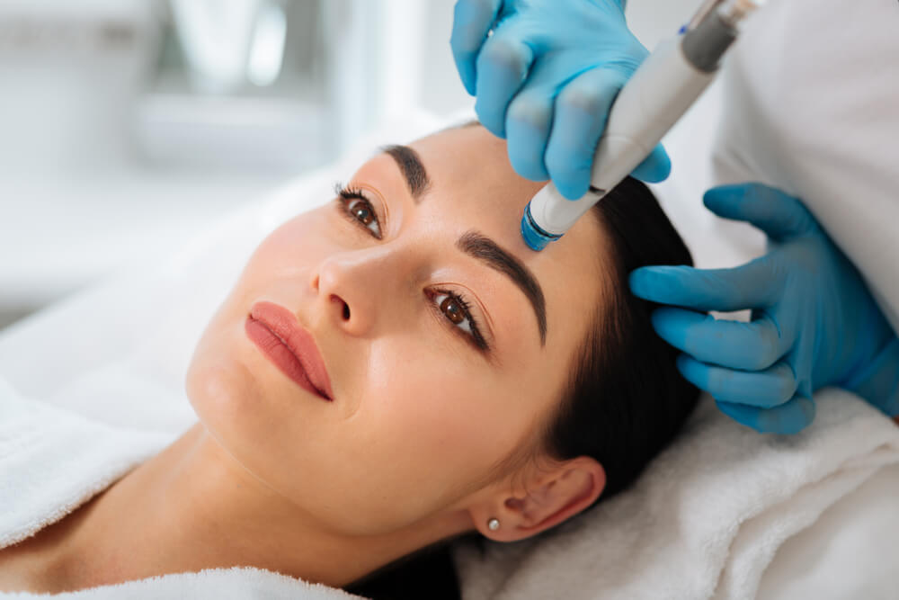 Face of a beautiful pleasant woman being cleansed during hydrafacial procedure